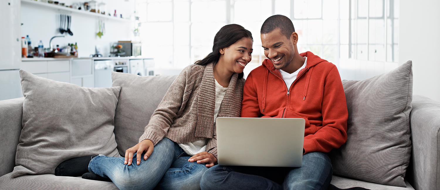Young couple researching professional packing companies on laptop.